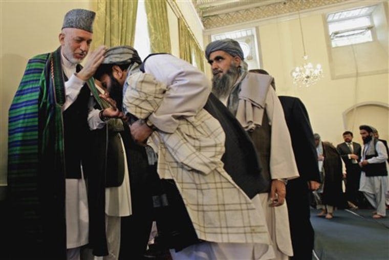 Afghan President Hamid Karzai, left, reacts after a man attempts to kiss his hand as he receives condolences during a memorial service for former Afghan President Burhanuddin Rabbani at the mosque of presidential palace in Kabul, Afghanistan, on Saturday Sept. 24. Rabbani was slain by a suicide bomber claiming to carry a peace message from the Taliban. 